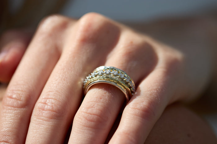 Aria two-tone spinner ring worn on the hand as a calming stress relief ring