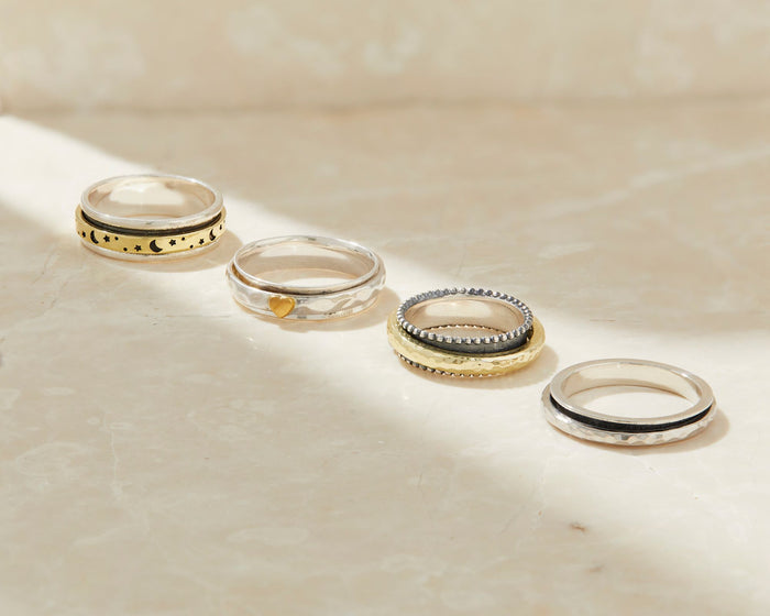 Engagement ring and wedding band stacked with delicate eternity bands in a bridal ring stack