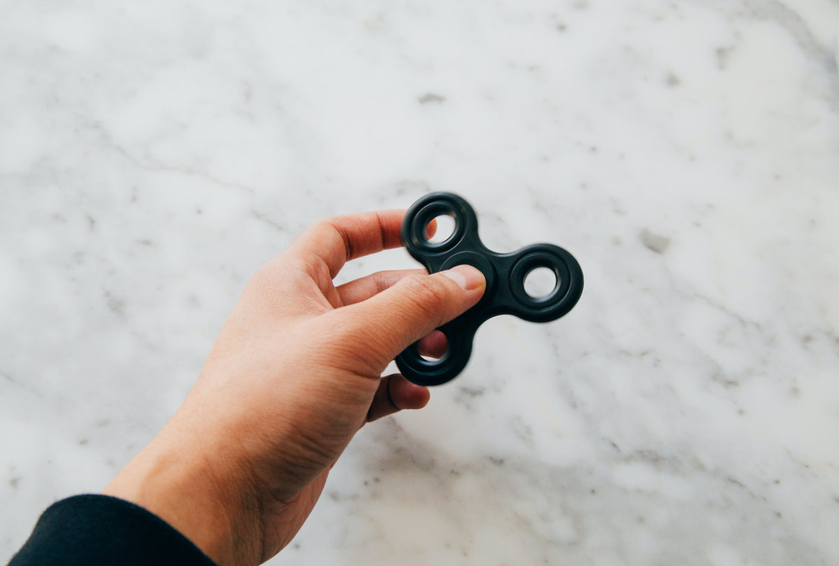 Hand wearing a spinner ring as a stylish fidget spinner alternative for calm and focus