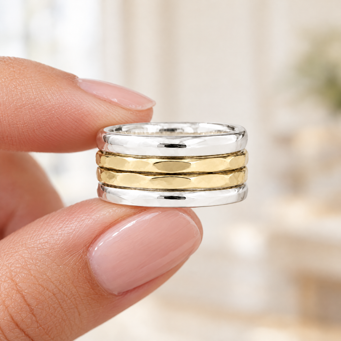 Hammered Four Band Stack Ring held in fingertips